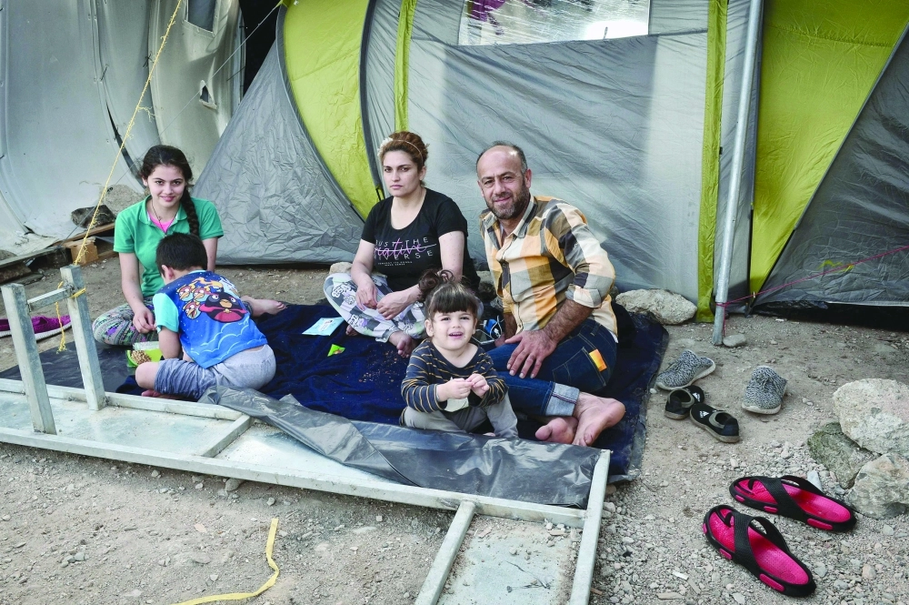 عائلة سورية من حلب في مخيم مؤقت بخيوس اليونانية ( أ ف ب)