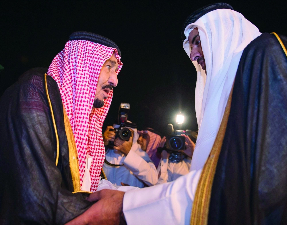 الملك سلمان مصافحا أمير قطر لدى وصوله الدوحة أمس الأول