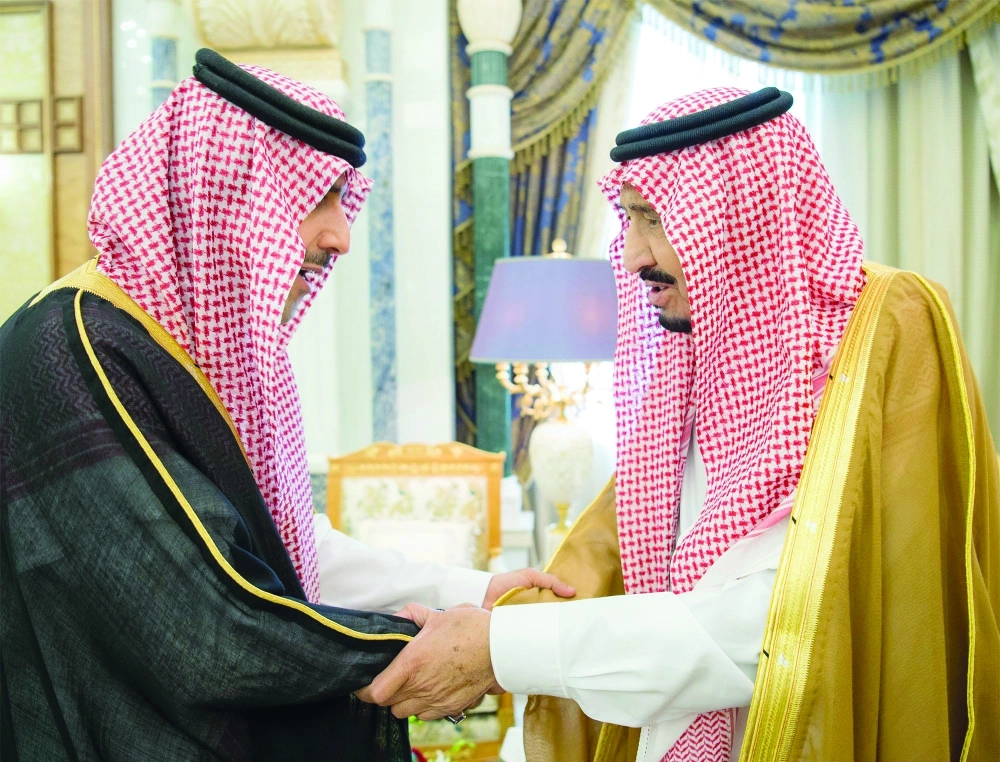 الملك سلمان مصافحا حسام العنقري خلال اللقاء