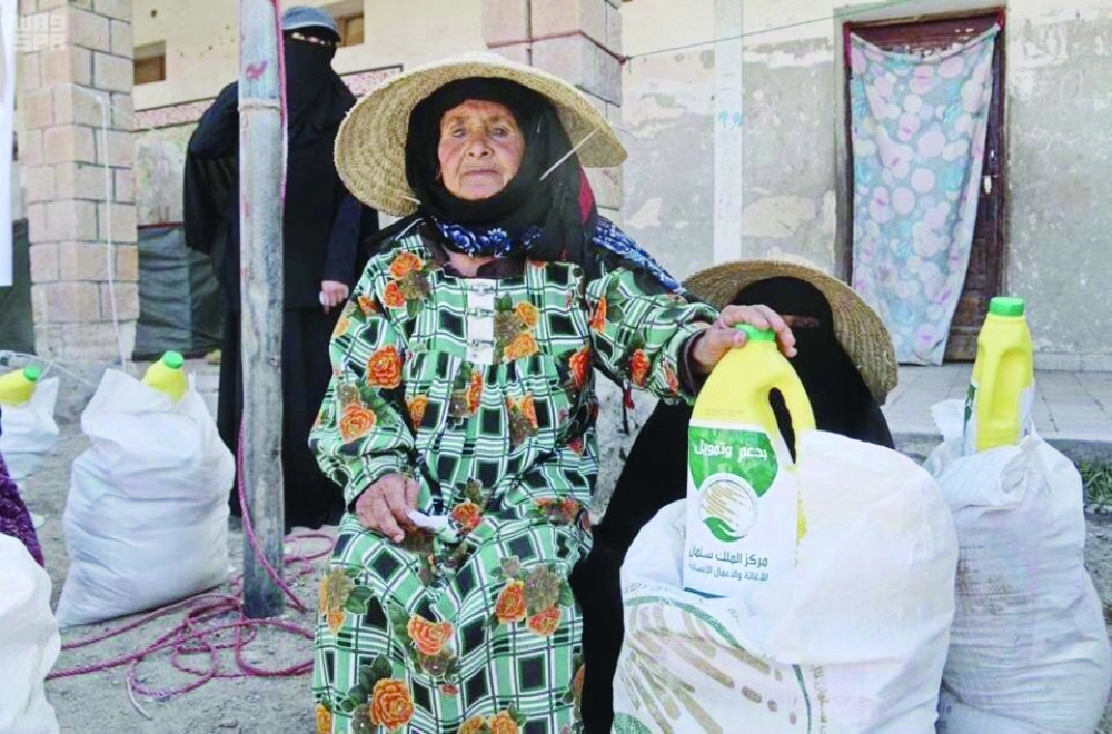 من توزيع مواد غذائية لمسنة في إحدى الدول الفقيرة   (واس)