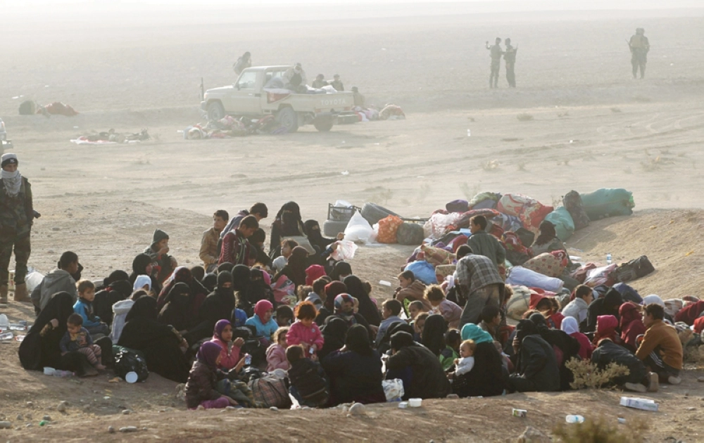 عراقيون من قرية عين ناصر جنوب الموصل يتجمعون خارج القرية التي تستعد القوات العراقية لدخولها كجزء من عملية تحرير المدينة من تنظيم داعش (أ ف ب) 