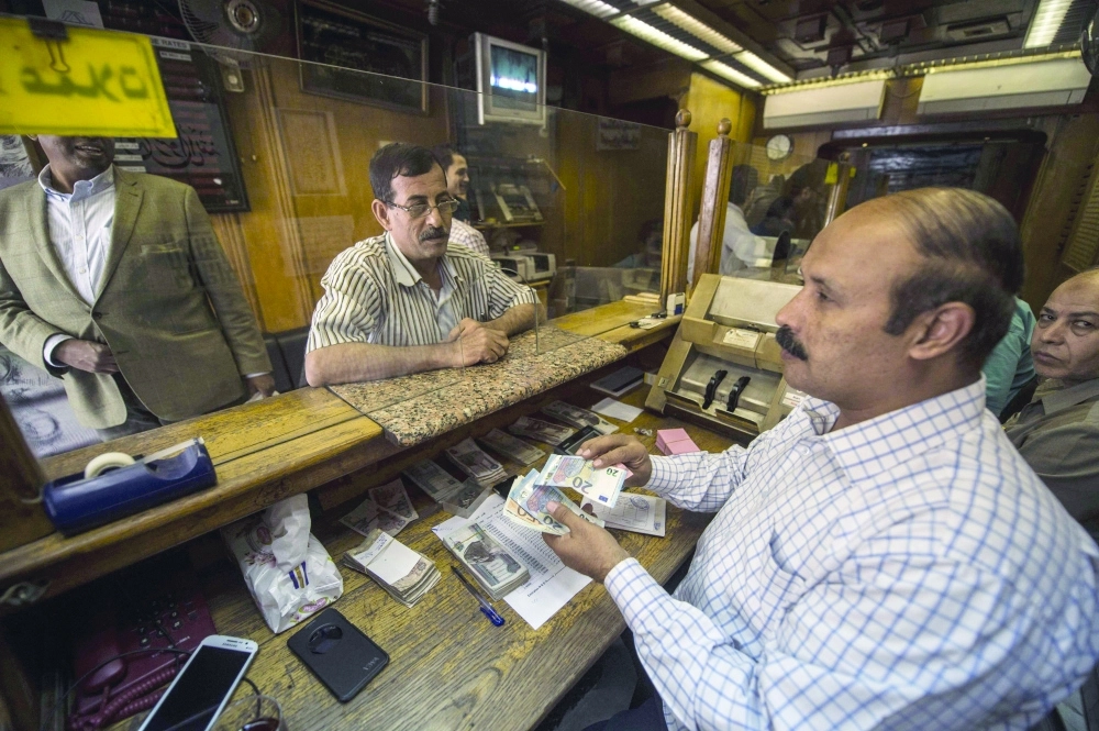 موظف يستبدل عملات في أحد المصارف المصرية        (رويترز)