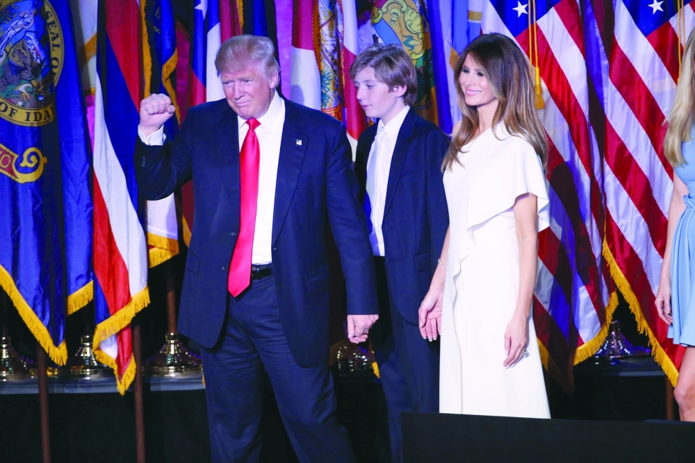 دونالد ترامب بجانب ابنه وزوجته ميلانيا أمس قبل إلقاء خطاب الفوز                       (إ ب أ)