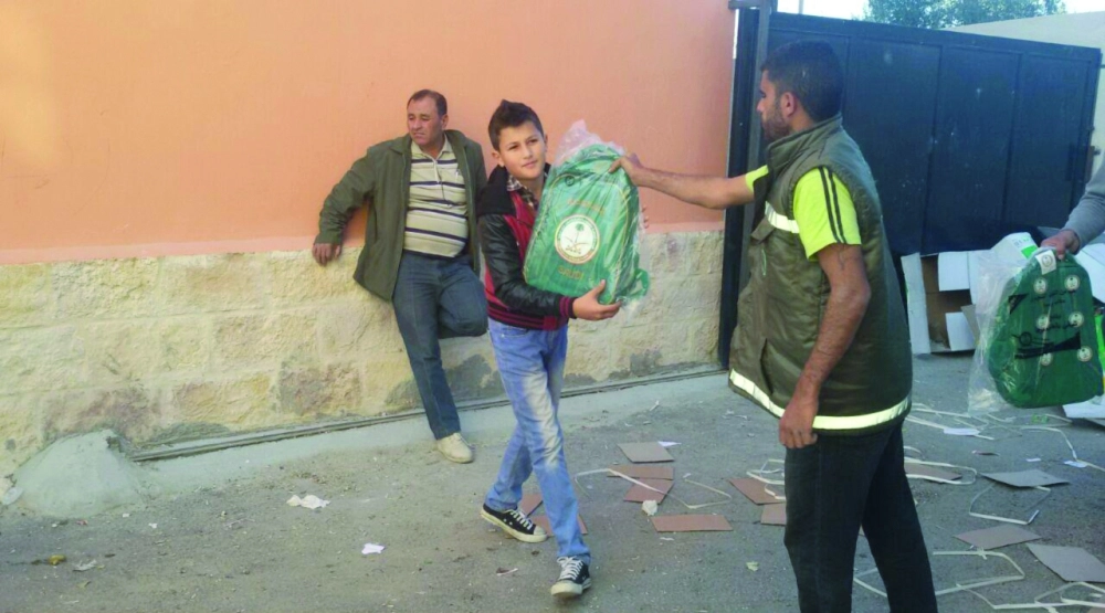 طالب سوري يتلقى مساعدات سعودية بعمان (واس)