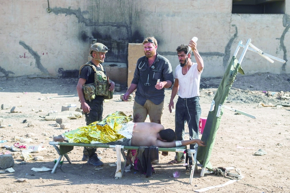 جريح يتلقى علاجا في عيادة ميدانية بالموصل                                                         (أ ف ب)