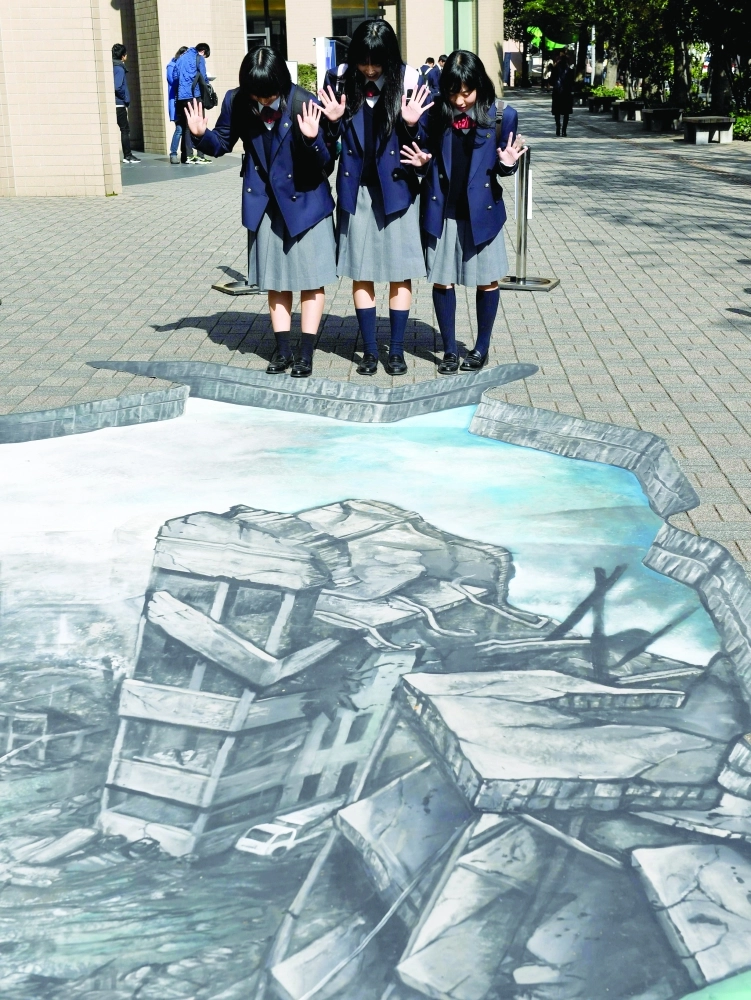  	
    طالبات يابانيات يطالعن لوحة ثلاثية الأبعاد لدمار حلب في طوكيو أمس (أ ف ب)

