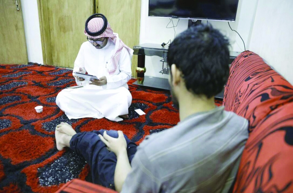 موظف يحدث بيانات أحد ذوي الاحتياجات الخاصة في منزله                     (مكة)