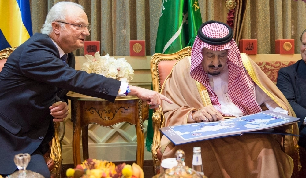 الملك سلمان مطلعا على إحدى المطبوعات 