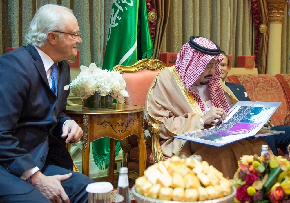 الملك سلمان مطلعا على إحدى المطبوعات 