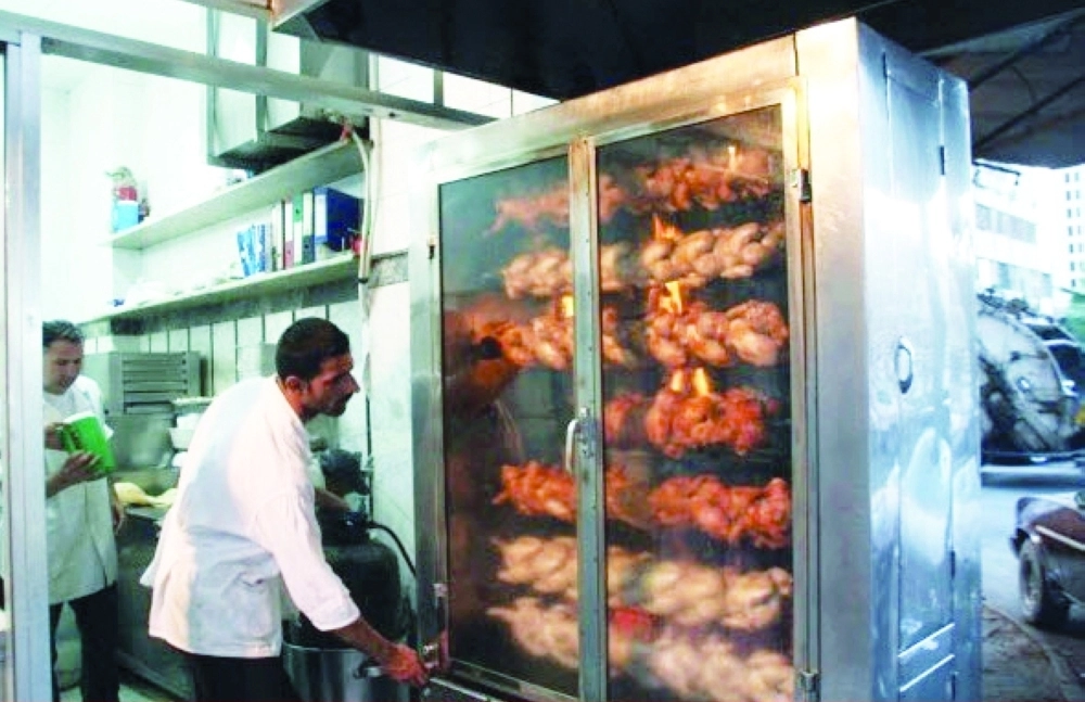 عامل أمام شواية دجاج (مكة)