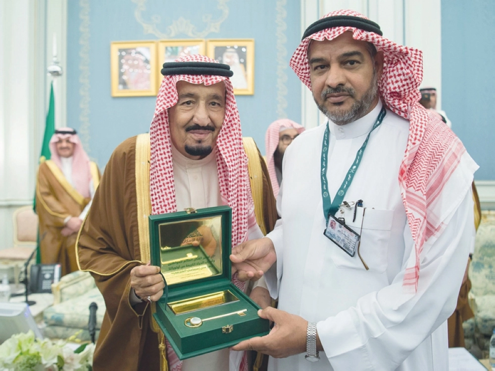 الملك سلمان مسلما أحد المواطنين مفتاح سكنه الجديد (واس)