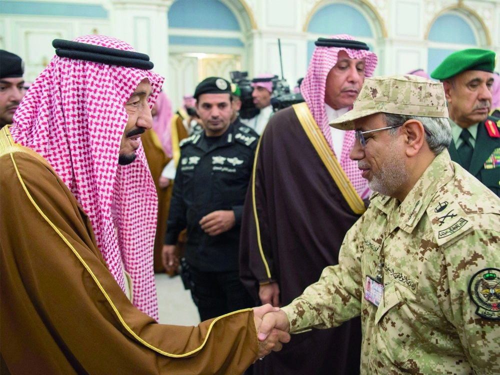 خادم الحرمين مصافحا أحد الضباط