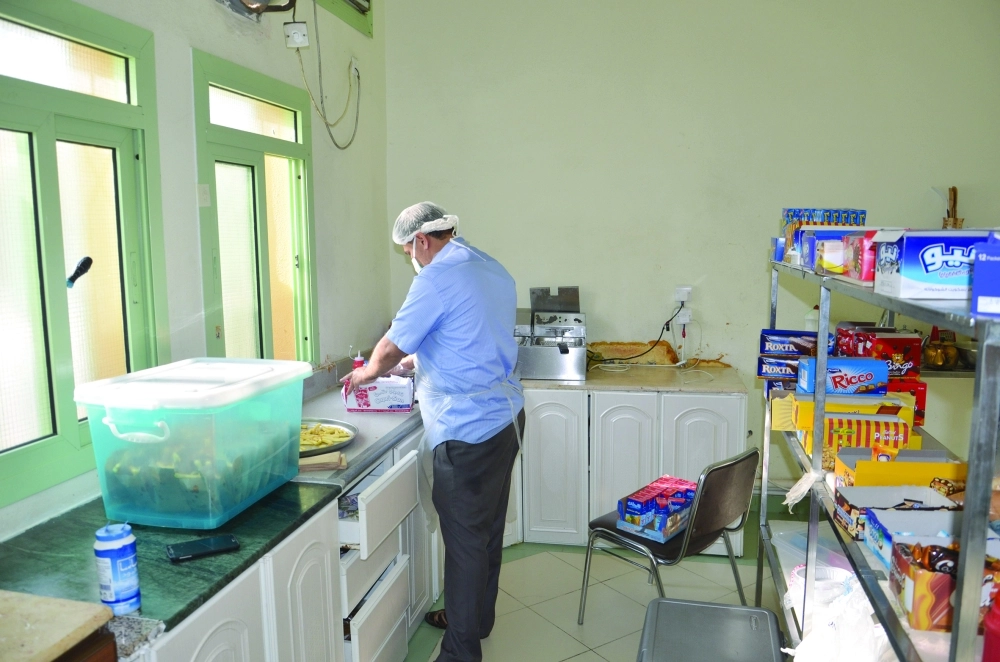 عامل يعد بطاطس مقلية لبيعها على الطلاب (عبدالمحسن دومان)