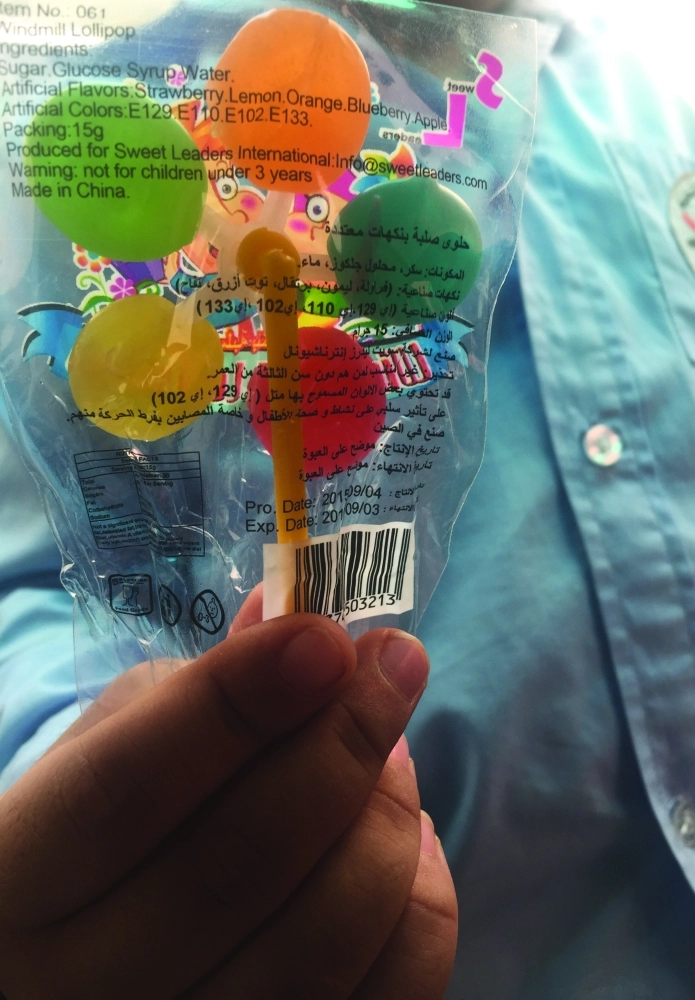 طفل يحمل حلوى اشتراها من مقصف روضة في مكة 