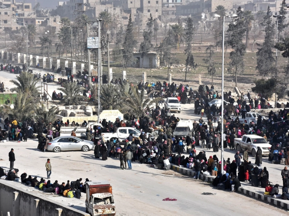 نزوح سكان من حلب الشرقية  أمس وتجمعهم في نقطة تفتيش تابعة لقوات النظام السوري ( أ ف ب )