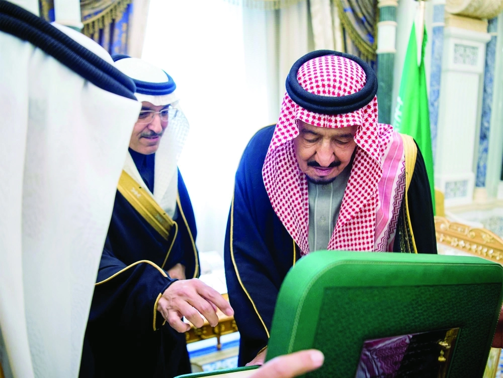الملك سلمان لدى تسلمه الرقم الأول من فئات الإصدار السادس للعملة 