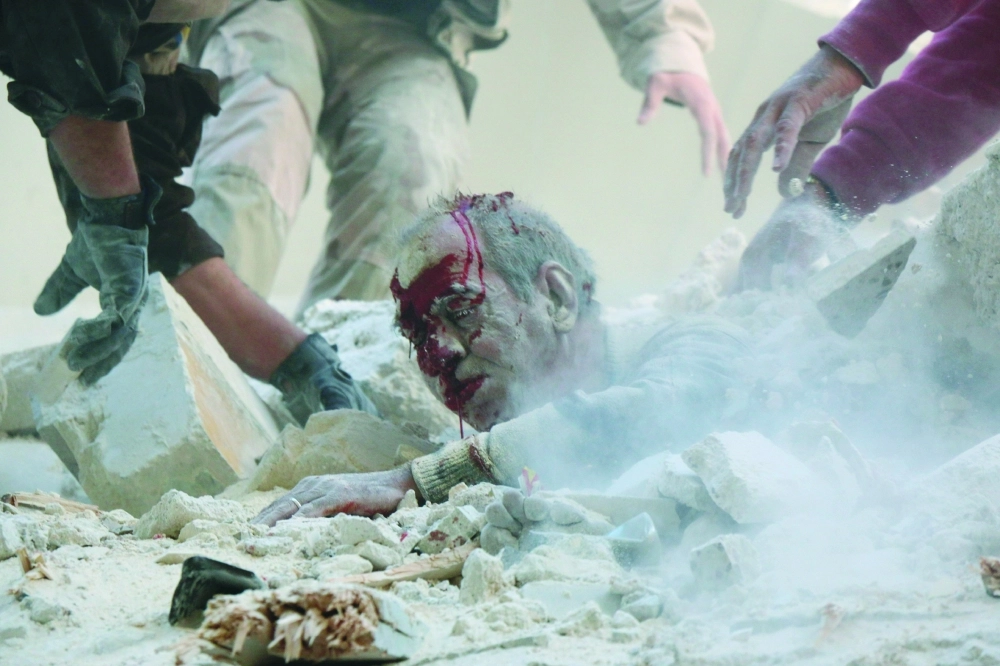 مسعفون يسحبون مدنيا من تحت الأنقاض عقب غارة للنظام على حلب (أ ف ب)