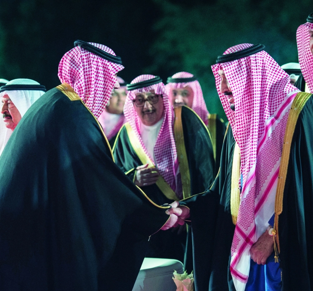 الملك سلمان مصافحا الشاعر مشعل الحارثي بعد إلقاء قصيدته في البحرين (بندر الجلعود)