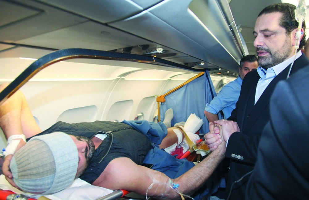 سعد الحريري مستقبلا مصابا في هجوم إسطنبول بمطار بيروت أمس                                (أ ب)