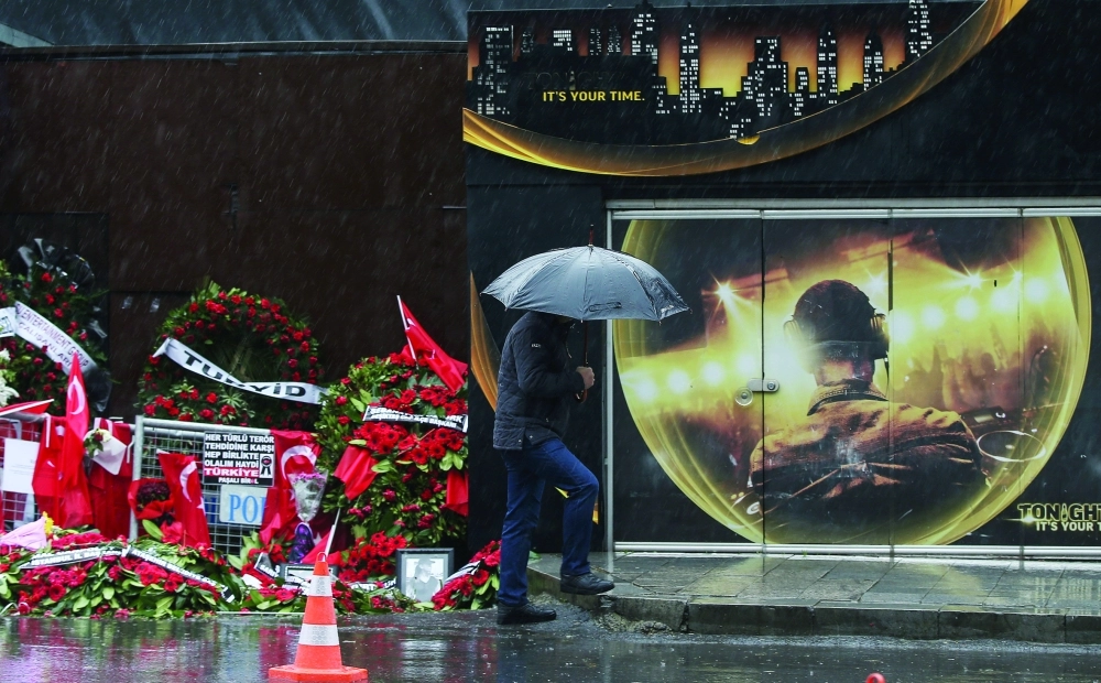 رجل يسير قرب زهور خارج موقع الهجوم بإسطنبول (أ ب)