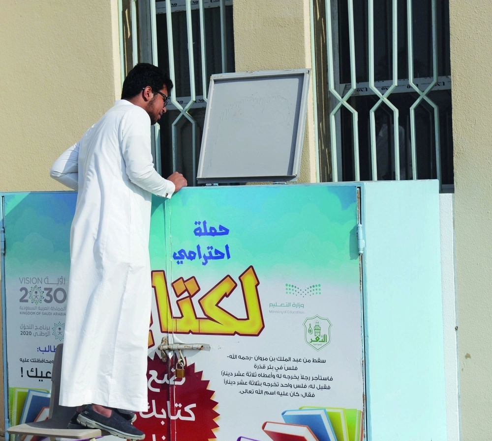 طالب بجانب صندوق جهزته مدرسة بجدة لحفظ الكتب خلال الاختبارات أمس (محمد يحيى)