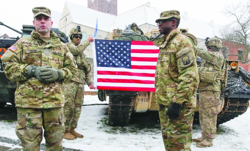 جنود أمريكيون يرفعون العلم خلال مراسم استقبالهم رسميا في بولندا       (أ ف ب)