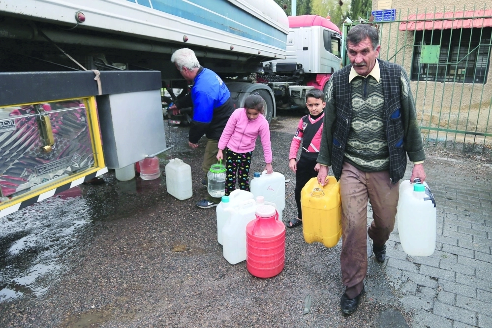 
سوريون يتحصلون على مياه من شاحنة في دمشق (أ ب)