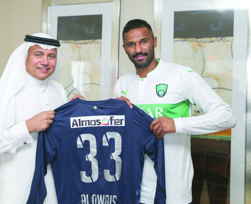 محمد العويس ملوحا بقميصه الجديد بمشاركة رئيس الأهلي أحمد المرزوقي                                                                      (إعلامي الأهلي)  