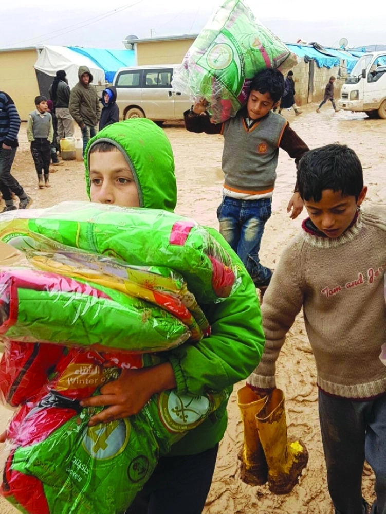 سوريون يتلقون مساعدات سعودية (واس)