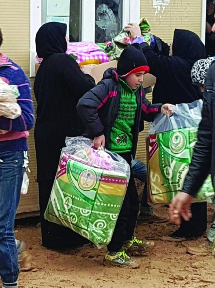 سوريون يتلقون مساعدات سعودية (واس)