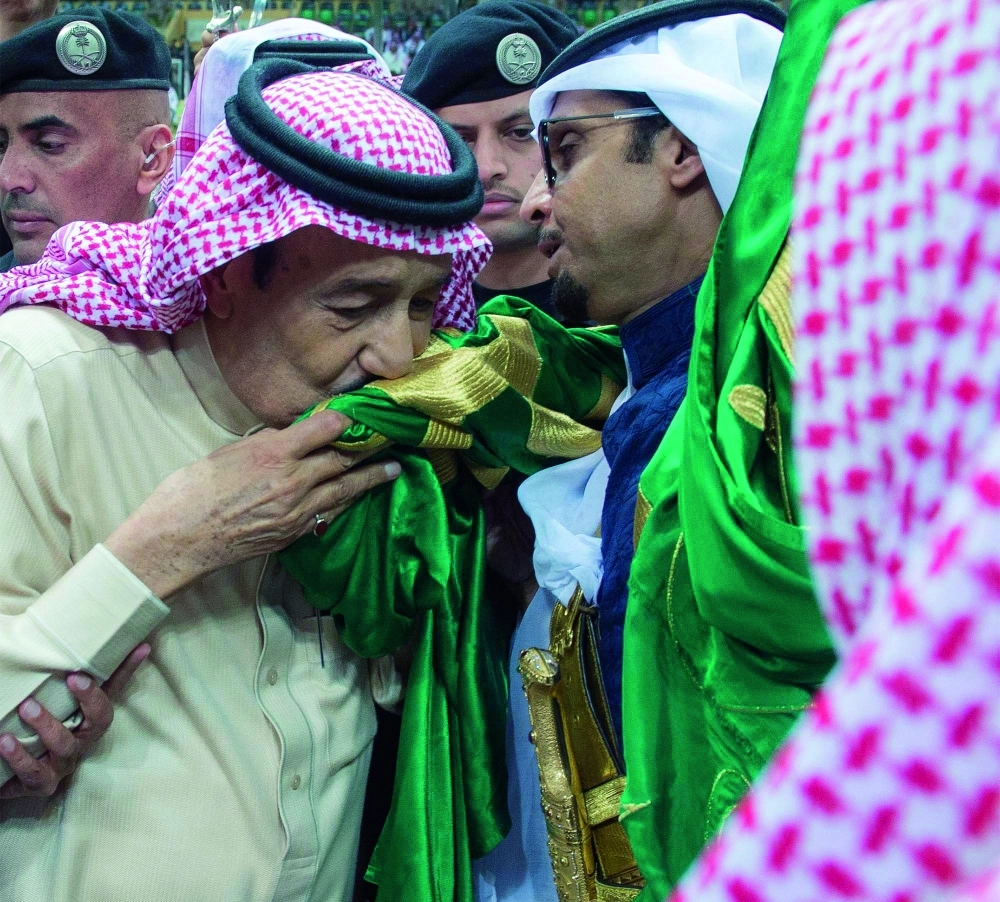 الملك سلمان مقبلا العلم خلال العرضة السعودية في جنادرية 30                    (واس)