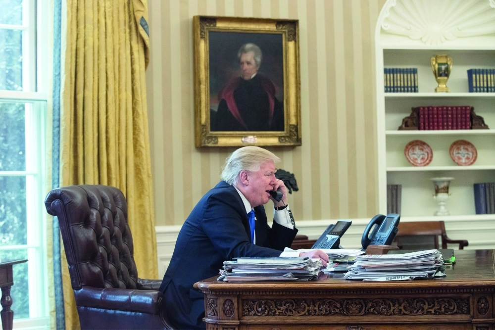 دونالد ترمب أثناء اتصال هاتفي مع إنجيلا ميركل أمس الأول                                                                        (إ ب أ)