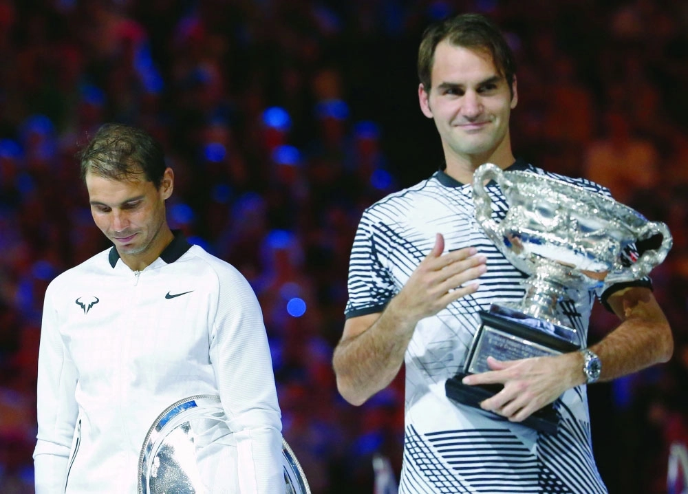 فيدرر عقب تتويجه وإلى جواره نادال                            (رويترز)