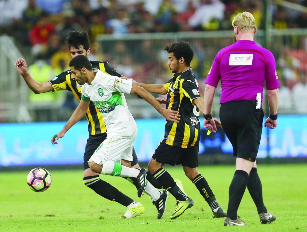 خالد السميري وفهد الأنصاري يحاولان تخليص الكرة من تيسير الجاسم (محمد يحيى)