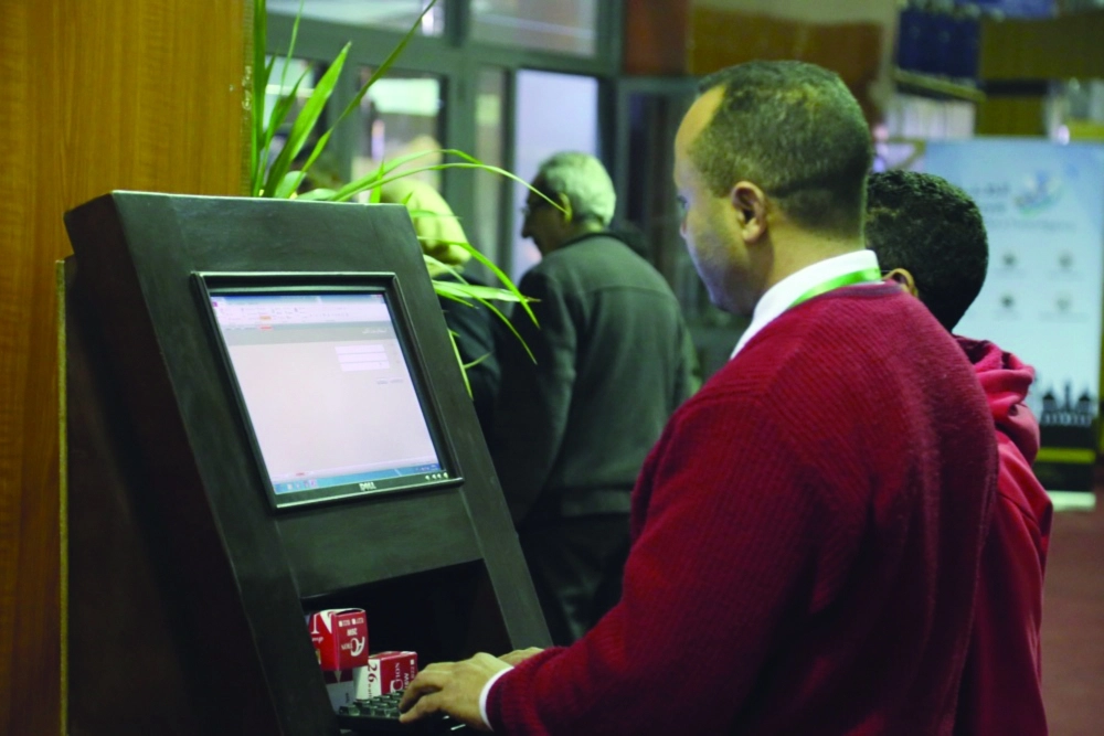 أحد زوار المعرض يبحث عن الكتب عبر الشاشات الالكترونية      (مكة)