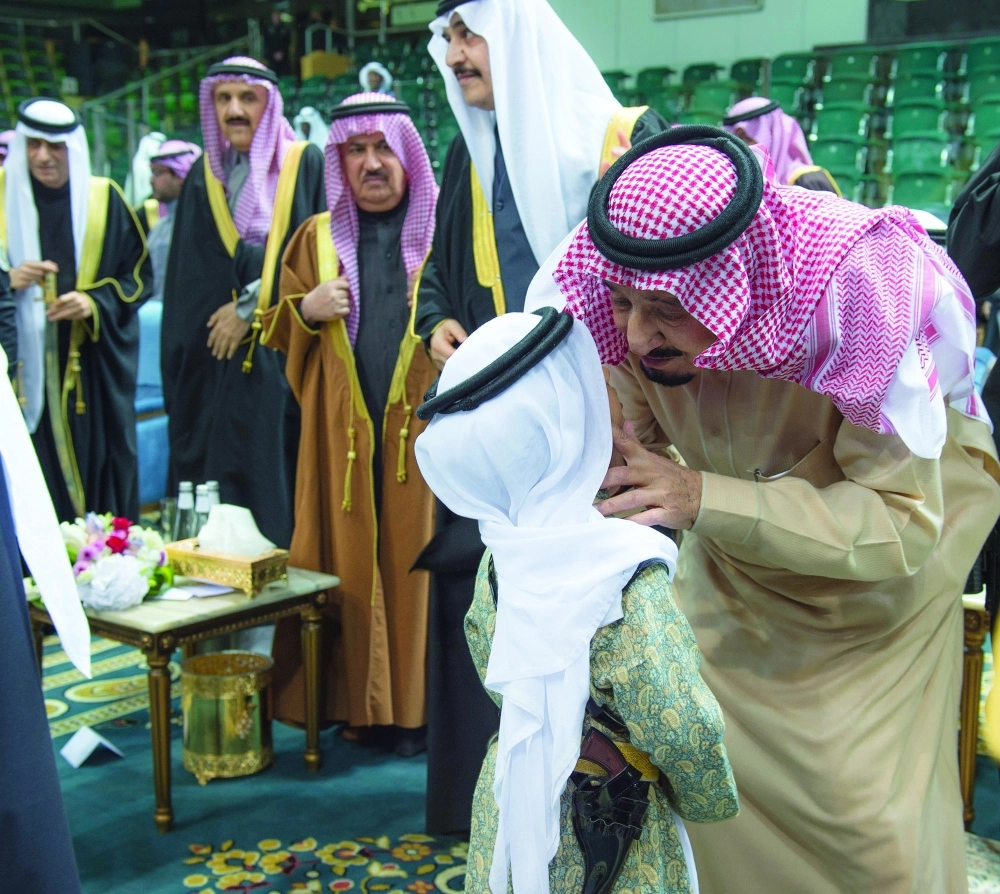 الملك سلمان يقبل أحد الأطفال