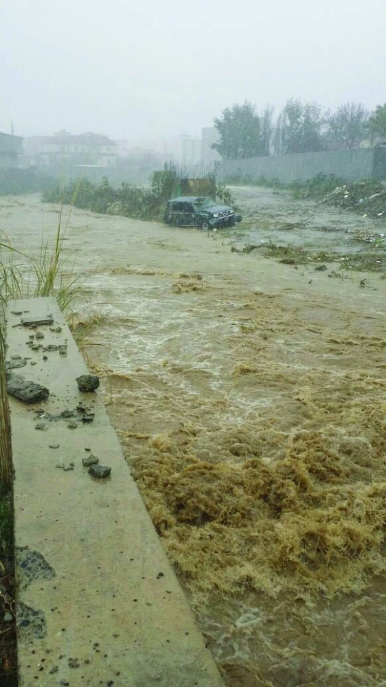 سيارة محتجزة جراء السيول على عسير أمس              (تويتر)        