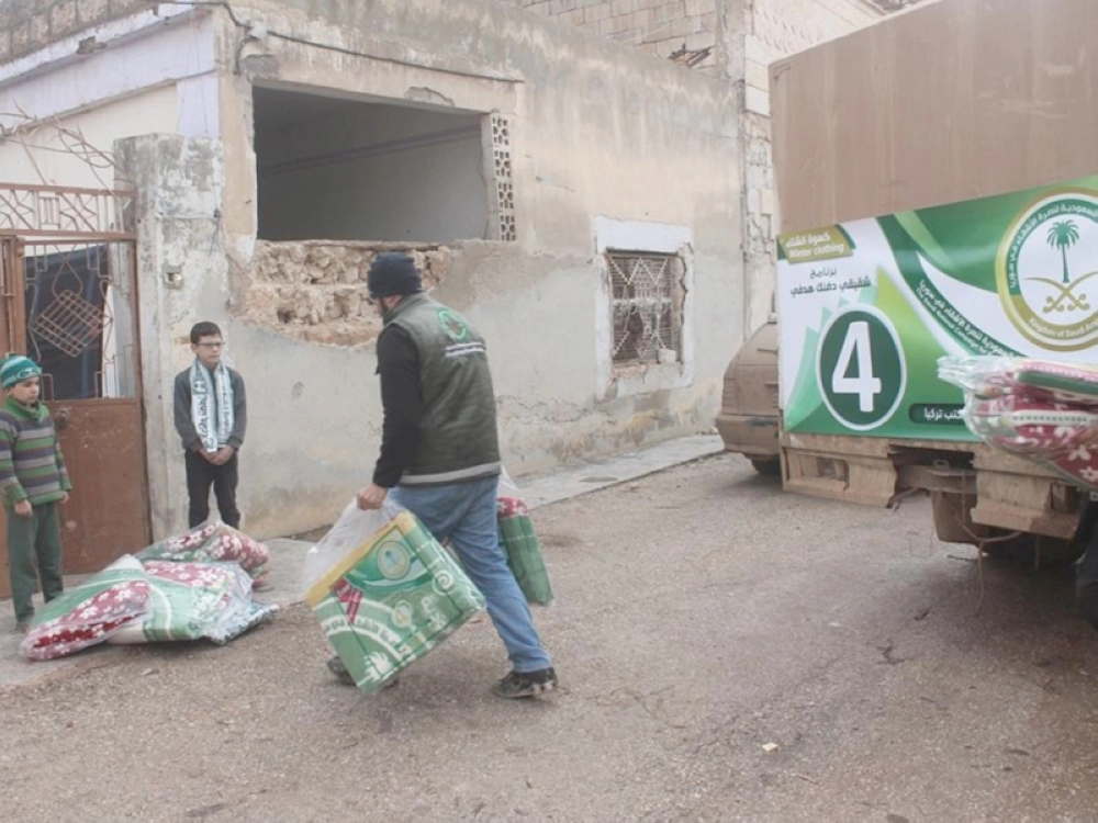 أحد أفراد الحملة السعودية بتركيا مقدما مساعدات لأسرة سورية مستفيدة أمس (واس)