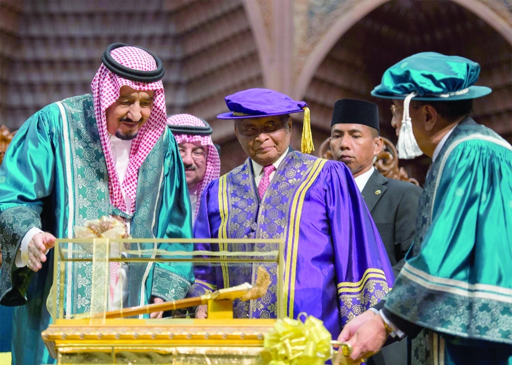 الملك سلمان متسلما هدية تذكارية بهذه المناسبة