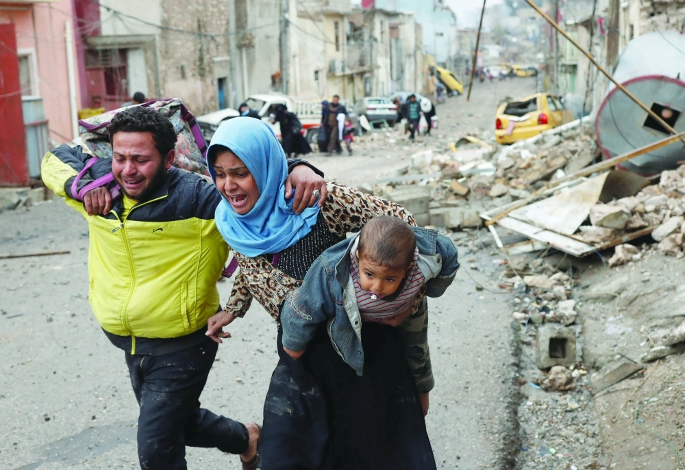 أسرة عراقية في حالة فزع وهي تفر من الموصل هربا من قتال داعش          (رويترز)