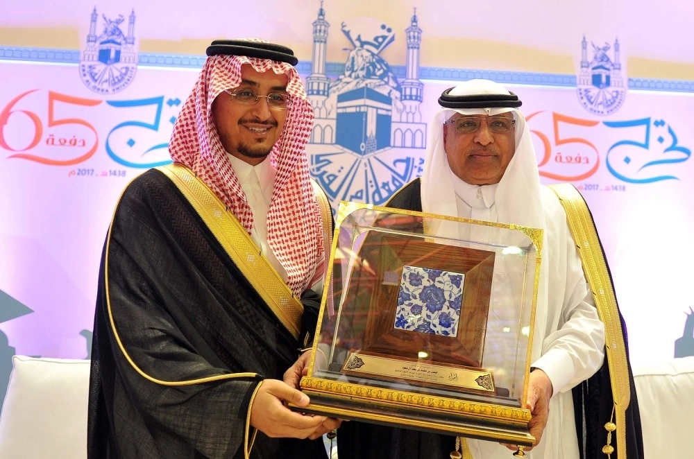 فيصل بن محمد يتسلم درع الجامعة من بكري عساس  (واس)