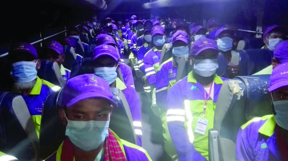 العمال يرتدون الكمامات وهم في طريقهم للعمل