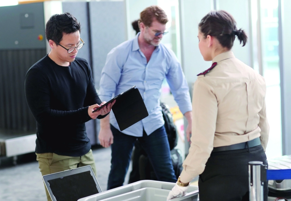 مسافر يكشف في نقطة الأمن بمطار أتاتورك بإسطنبول أمس عن الأجهزة الالكترونية   (إ ب أ)