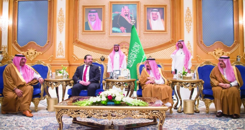 الملك وبرفقته الحريري بحضور أمير الرياض وولي العهد في قاعدة الملك سلمان (واس)