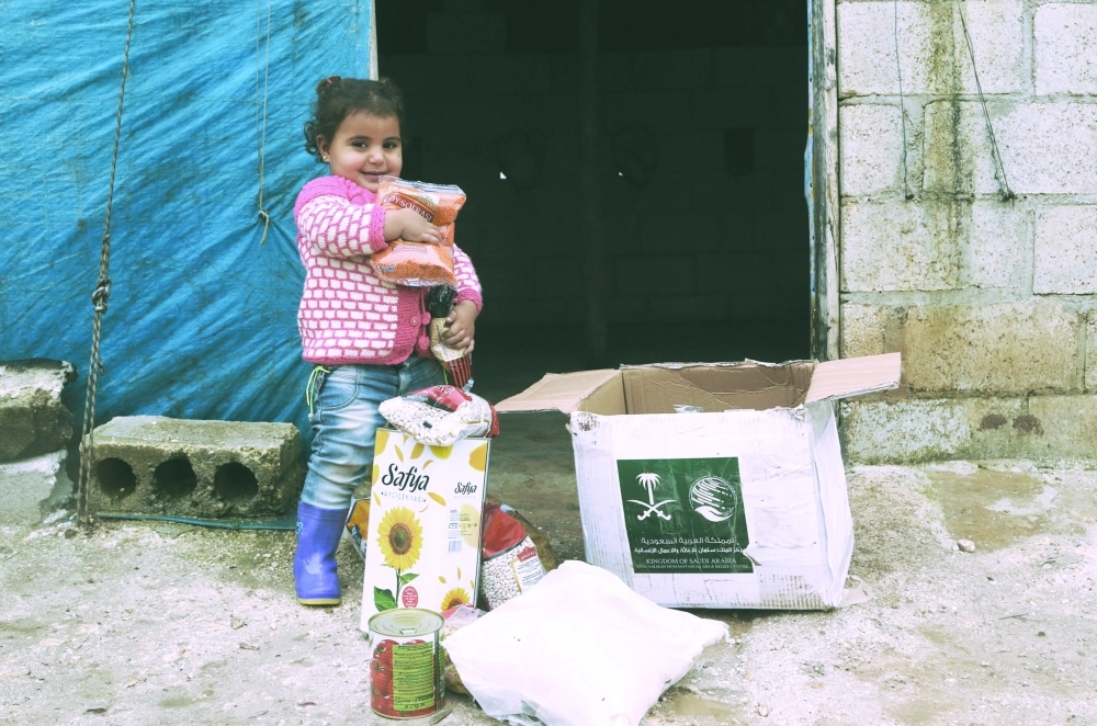 طفلة سورية تتلقى مساعدات من مركز الملك سلمان بإدلب