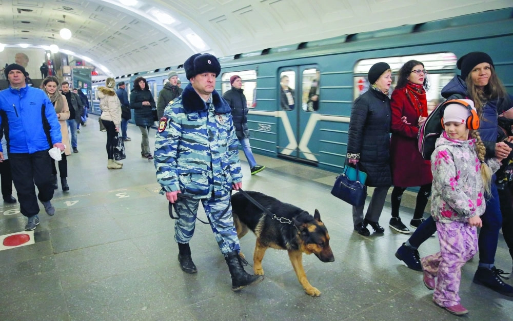 شرطي روسي يتجول بكلب مدرب في محطة مترو بموسكو أمس            (رويترز)