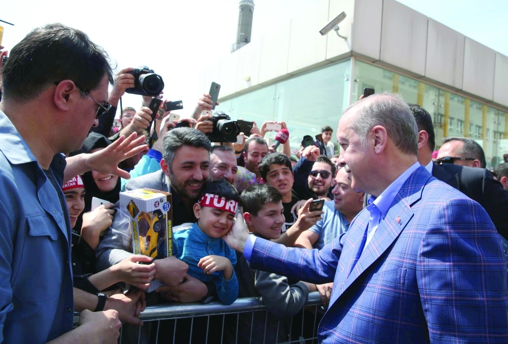 إردوغان يصافح أنصاره خارج مركز اقتراع في إسطنبول أمس      (رويترز)