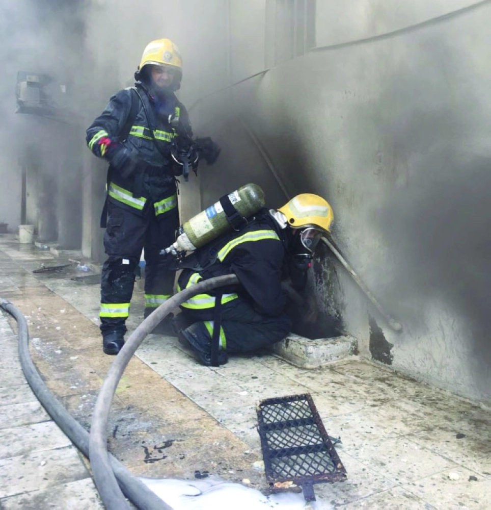 رجلا إطفاء يخمدان الحريق                                  (مكة)