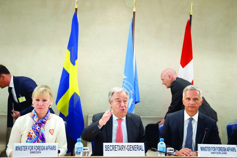 جوتيريس يتوسط راعيا المؤتمر بجنيف (إ ب أ)