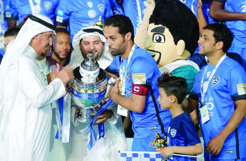 قائد الهلال ياسر القحطاني ونائب رئيس النادي عبدالرحمن النمر يتسلمان الكأس أمس